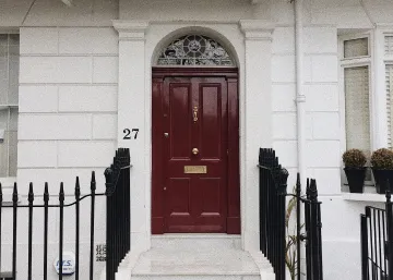 red door with ornate design in glazing above installed by our window and door contractor